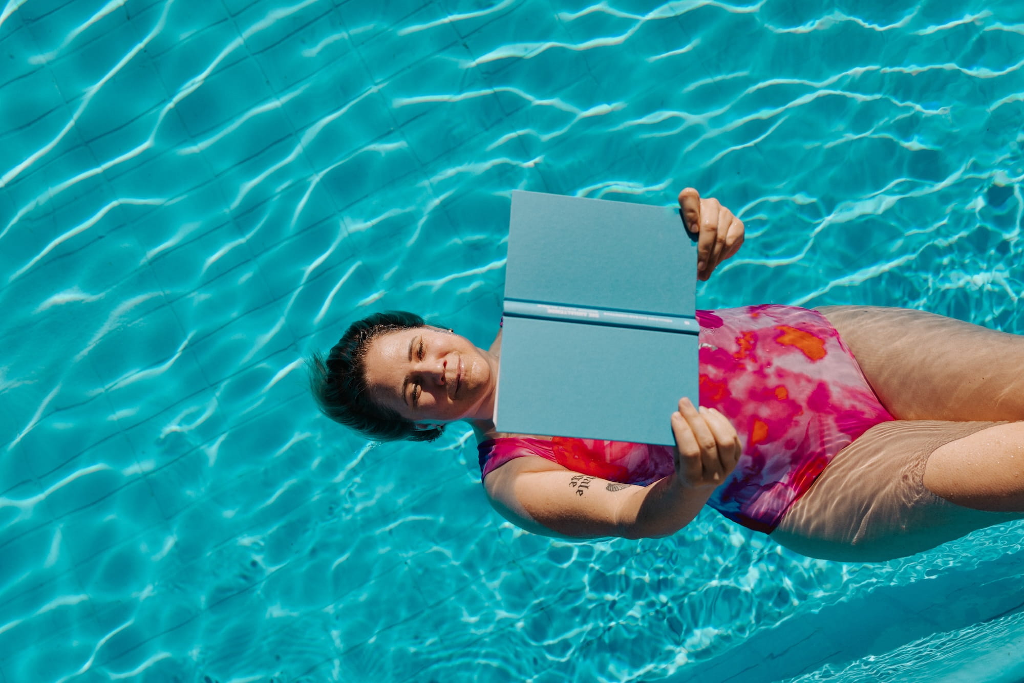 Louisa beim Lesen im Wasser